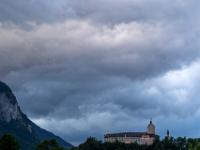 Graue und helle Wolken über abendlich beleuchtetem Schloß Hohenaschau